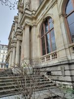 (2026) Escaliers et entrée du Palais de la Bourse du côté de la place de la Bourse. On peut voir la plaque « Mémoire de Lyon » en bas à droite de la photo.